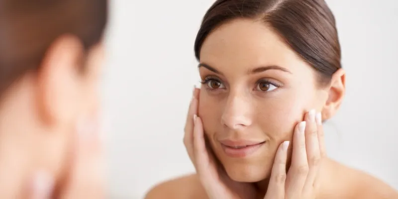 Woman looking at her skin.